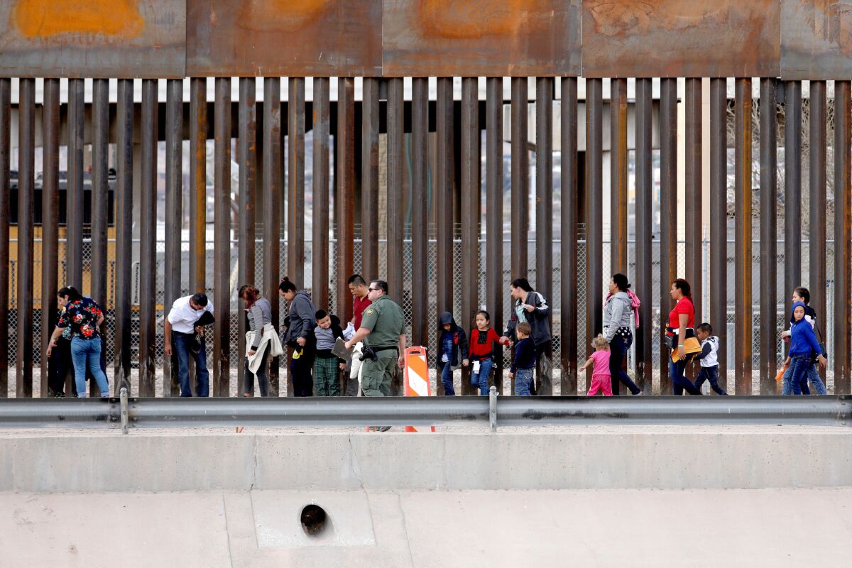 Migrants seeking asylum turn themselves in to U.S. Border Patrol agents on the El Paso side of the Rio Grande bordering Ciudad Juarez, Mexico. (Gary Coronado / Los Angeles Times)