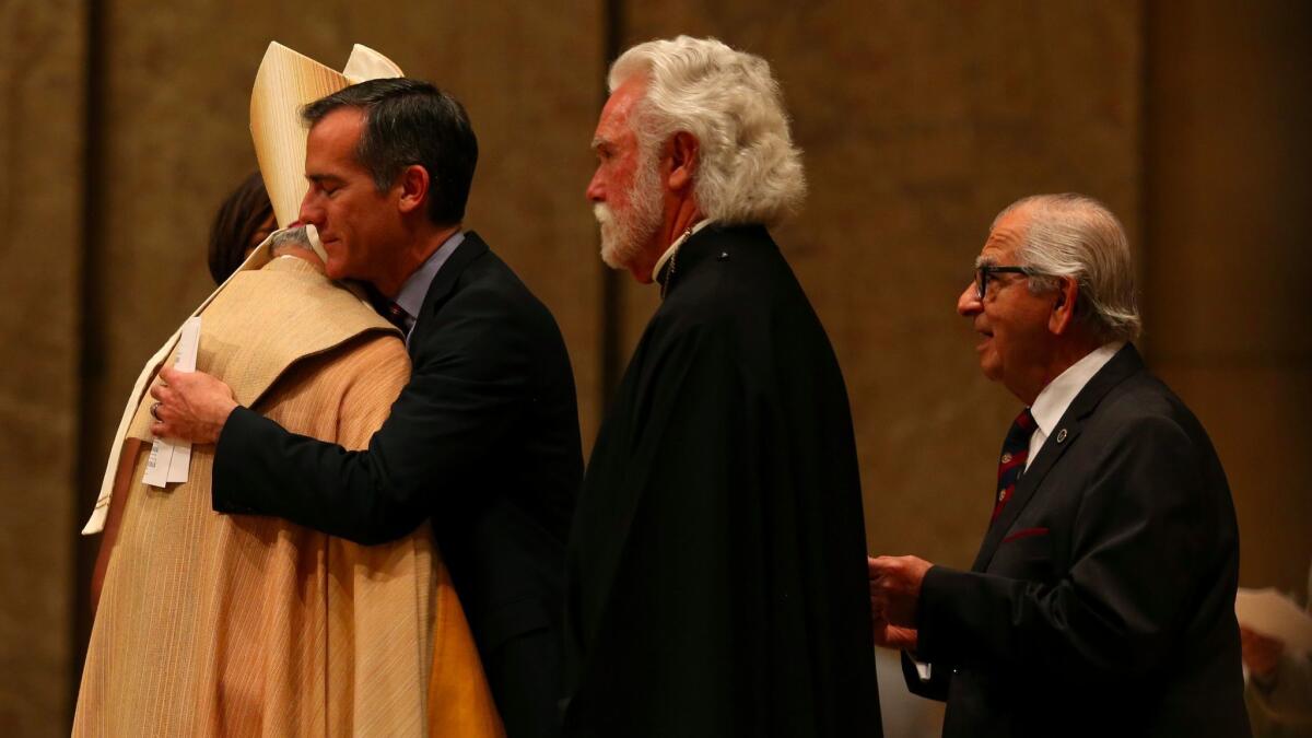 LA mayor Eric Garcetti hugs Archbishop Jose H. Gomez, following an interfaith prayer service for peace and unity at the Cathedral of Our Lady of the Angels.