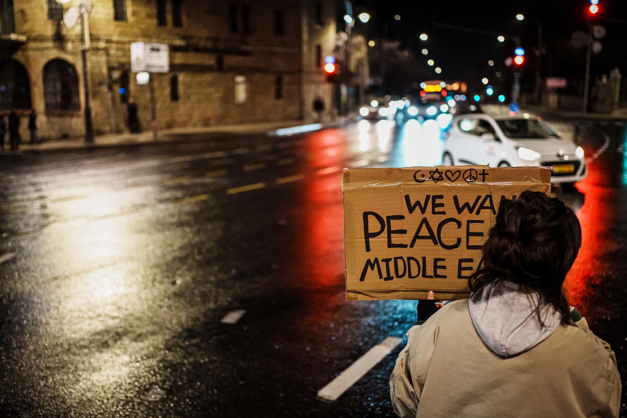A protester holds a sign at night