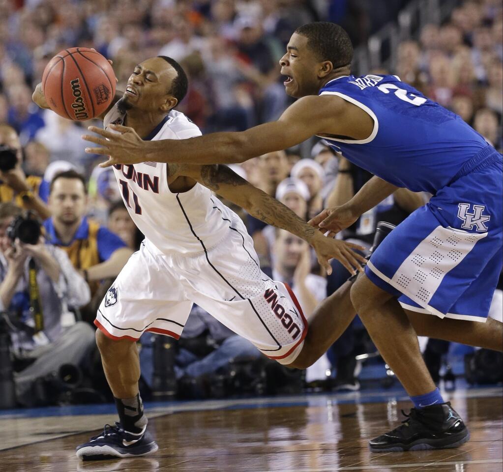 Connecticut guard Ryan Boatright, left, fights for a loose ball with Kentucky guard Aaron Harrison during the second half of the Huskies' 60-54 win in the NCAA men's basketball championship game Monday.