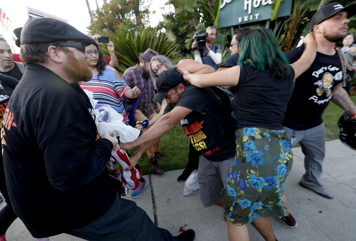 Supporters and opponents of President Trump clash at the intersection of Sunset Boulevard and Benedict Canyon Road in Beverly Hills on Tuesday, while Trump attended a fundraiser.