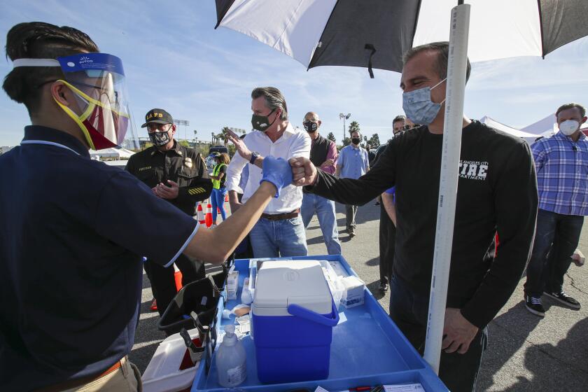 Los Angeles, CA - January 15: Mayor Eric Garcetti, right, and Governor Gavin Newsom tour mass COVID-19 vaccination site at Dodger Stadium on Friday, Jan. 15, 2021 in Los Angeles, CA. (Irfan Khan / Los Angeles Times)