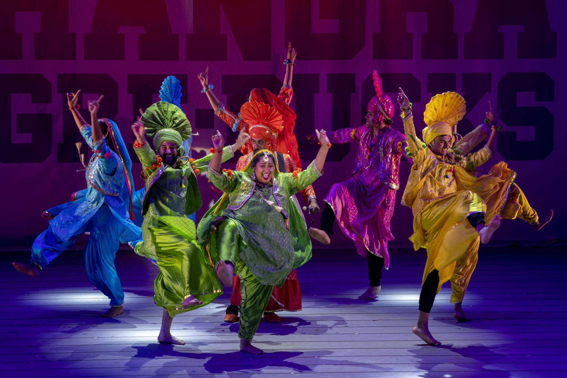 Performer dance in vibrant colorful costumes onstage 