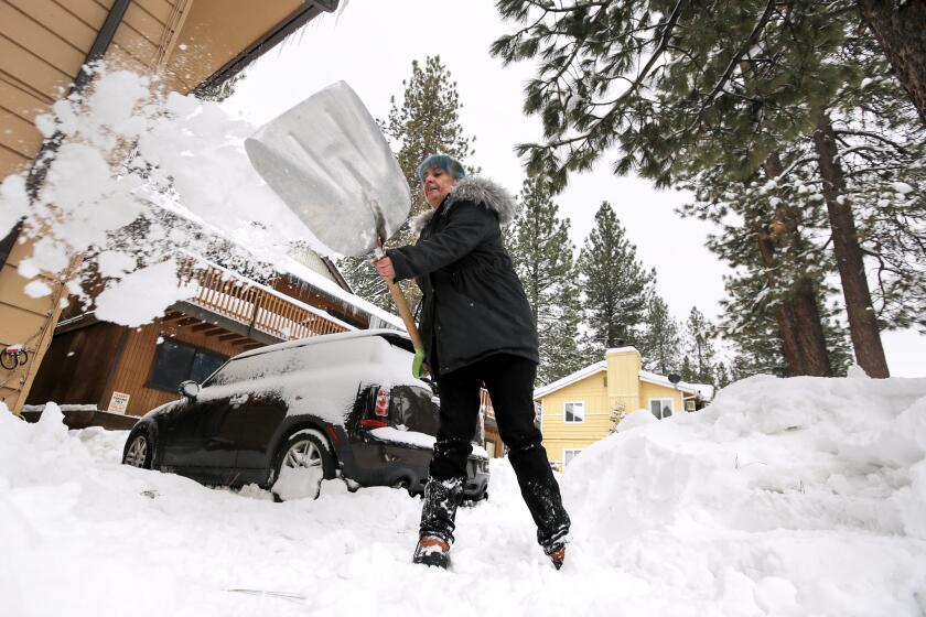 BIG BEAR LAKE, CA - FEBRUARY 28: Amblerlee Barden shovels snow after successive storms dumped several feet of snow blocking her driveway on Tuesday, Feb. 28, 2023 in Big Bear Lake, CA. (Brian van der Brug / Los Angeles Times)