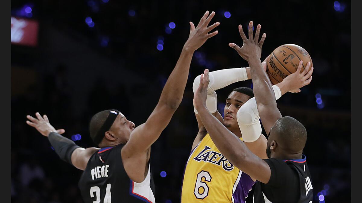 Lakers guard Jordan Clarkson (6) tries to pass while defended by Clippers Raymond Felton, right, and Paul Pierce during the first half at Staples Center.