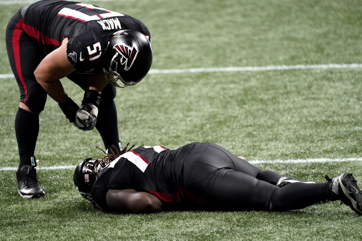 Atlanta Falcons offensive guard James Carpenter (77) lies injured against the Las Vegas Raiders during the second half of an NFL football game, Sunday, Nov. 29, 2020, in Atlanta. Carpenter had to leave the field.(AP Photo/John Bazemore)