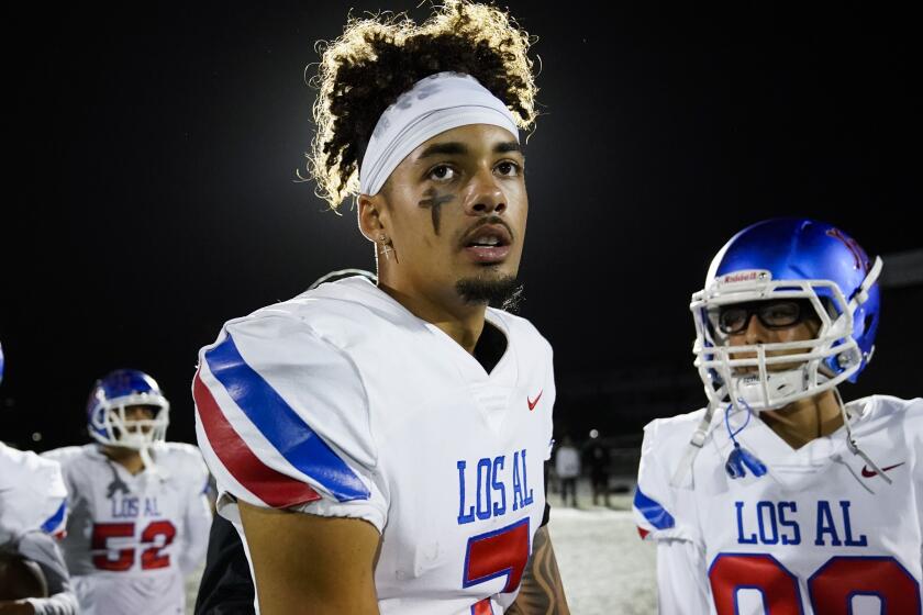 Los Alamitos High School quarterback Malachi Nelson stands on the field after a high school football game 