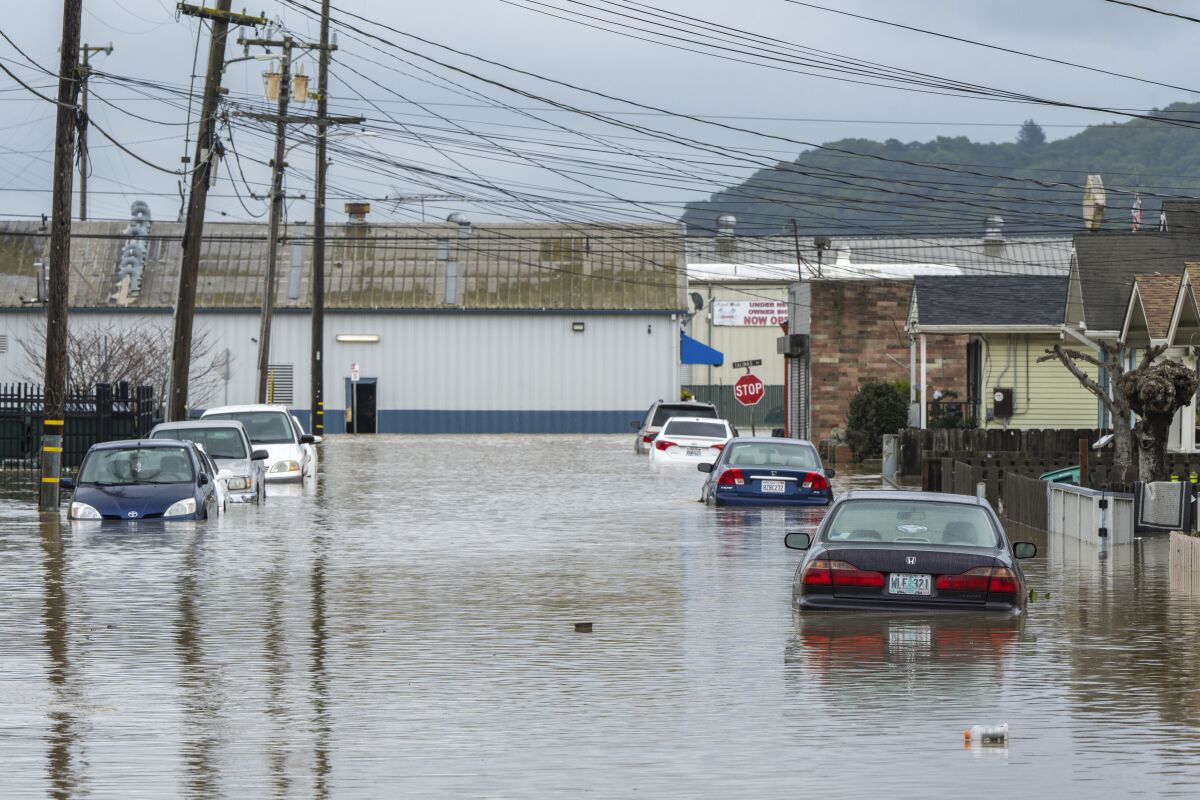 Cars were partially submerged next to houses in the flood waters.