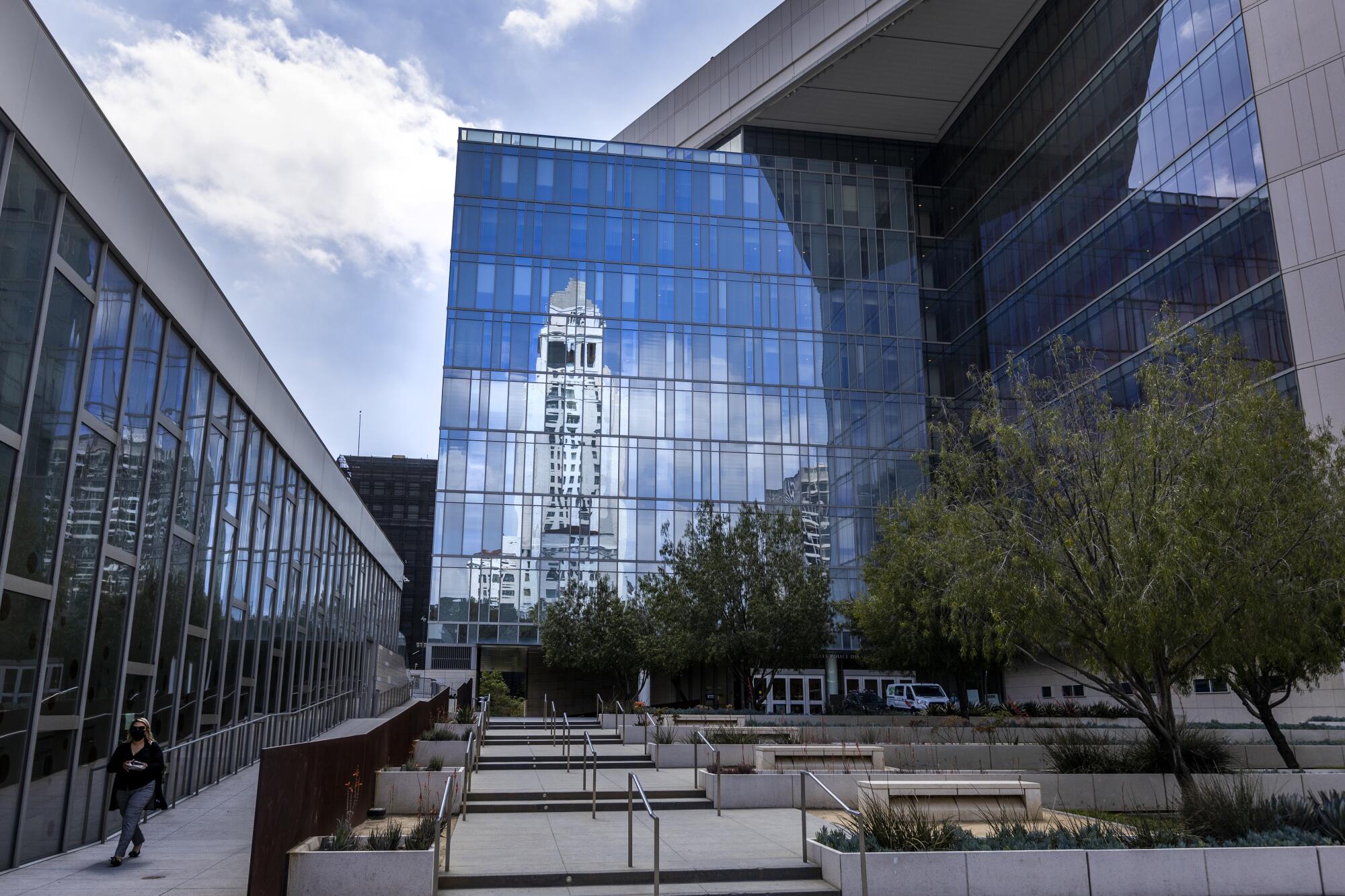 Los Angeles City Hall is reflected in the windows of the LAPD headquarters on April 20, 2022.