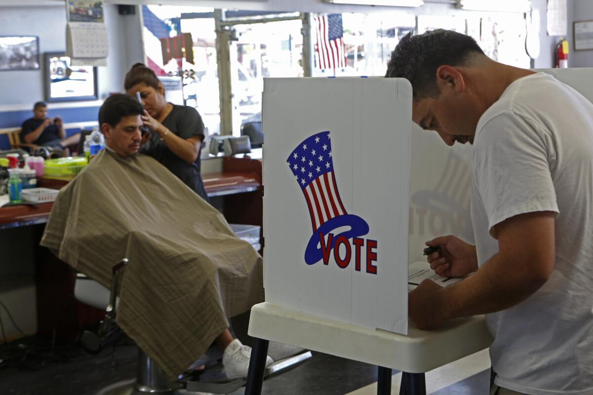Big donors dominated in California congressional primaries, a watchdog group's report says. Here, a voter casts his ballot in a Long Beach barber shop on June 3.