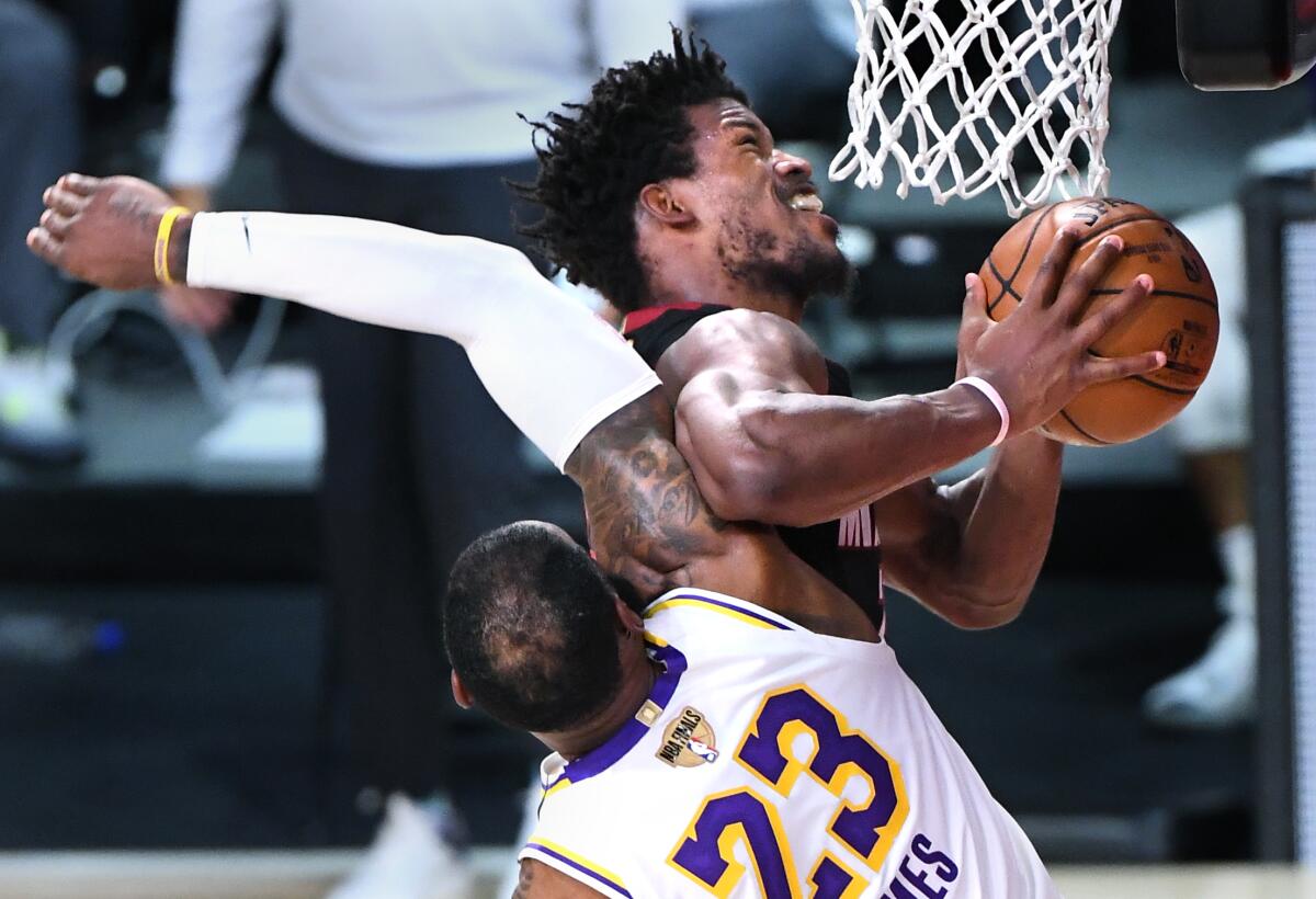 Lakers forward LeBron James fouls Miami forward Jimmy Butler.