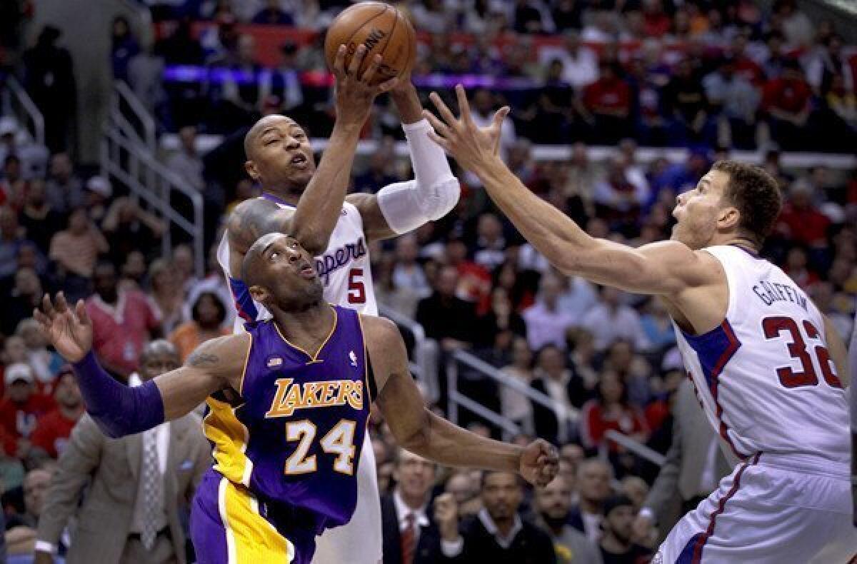 Clippers forward Caron Butler goes above Lakers guard Kobe Bryant to try to snag a rebound in the game Sunday afternoon.