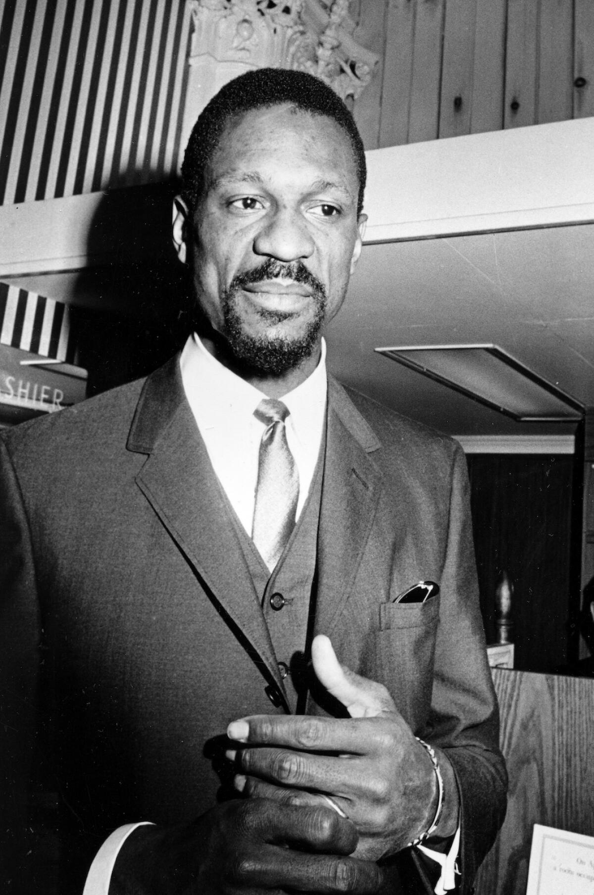 Black-and-white image of a man in a three-piece-suit from the documentary series "Bill Russell: Legend."