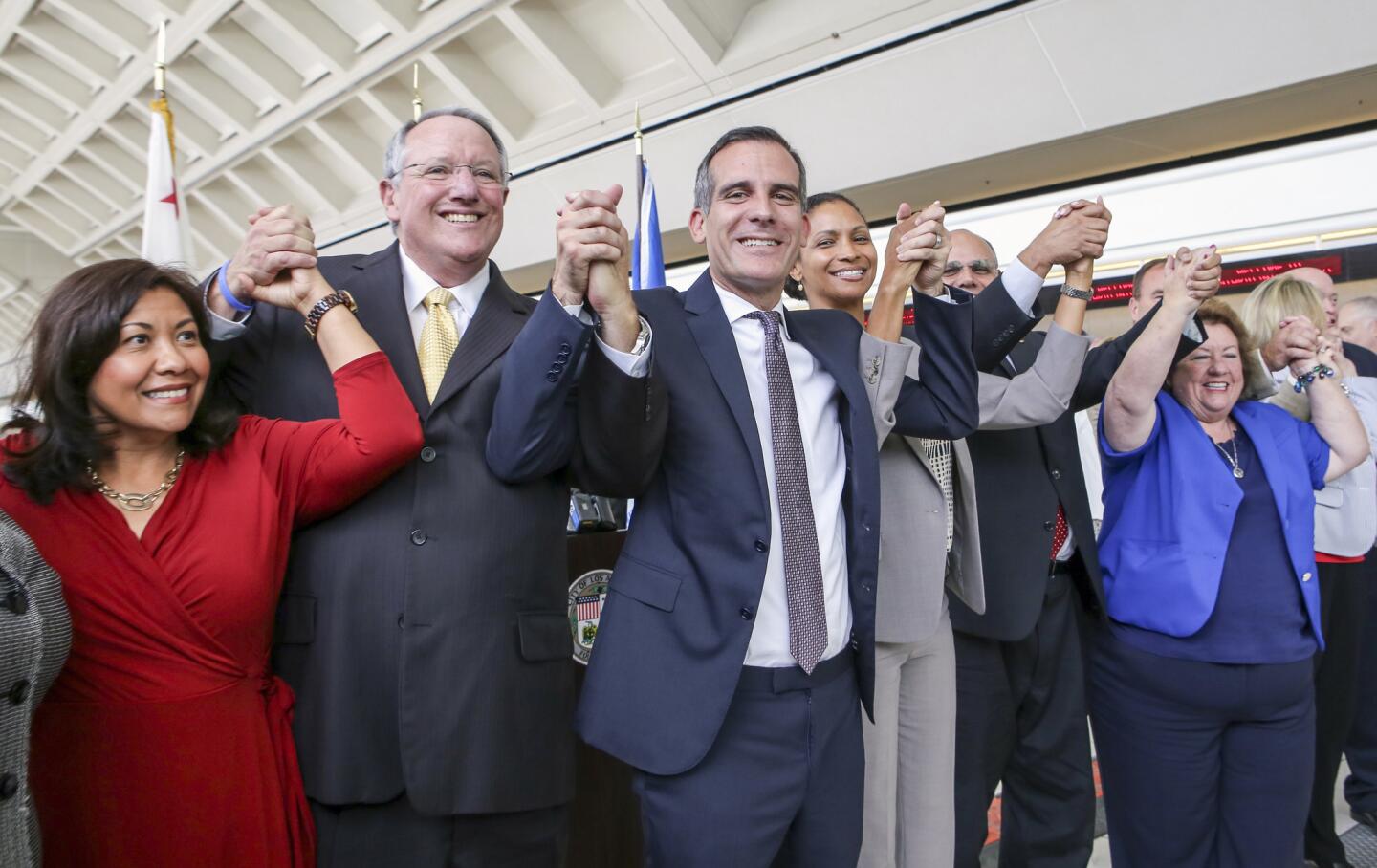 Ontario Mayor Pro Tem Alan D. Wapner, second from left, and Los Angeles Mayor Eric Garcetti join hands to celebrate the agreement.