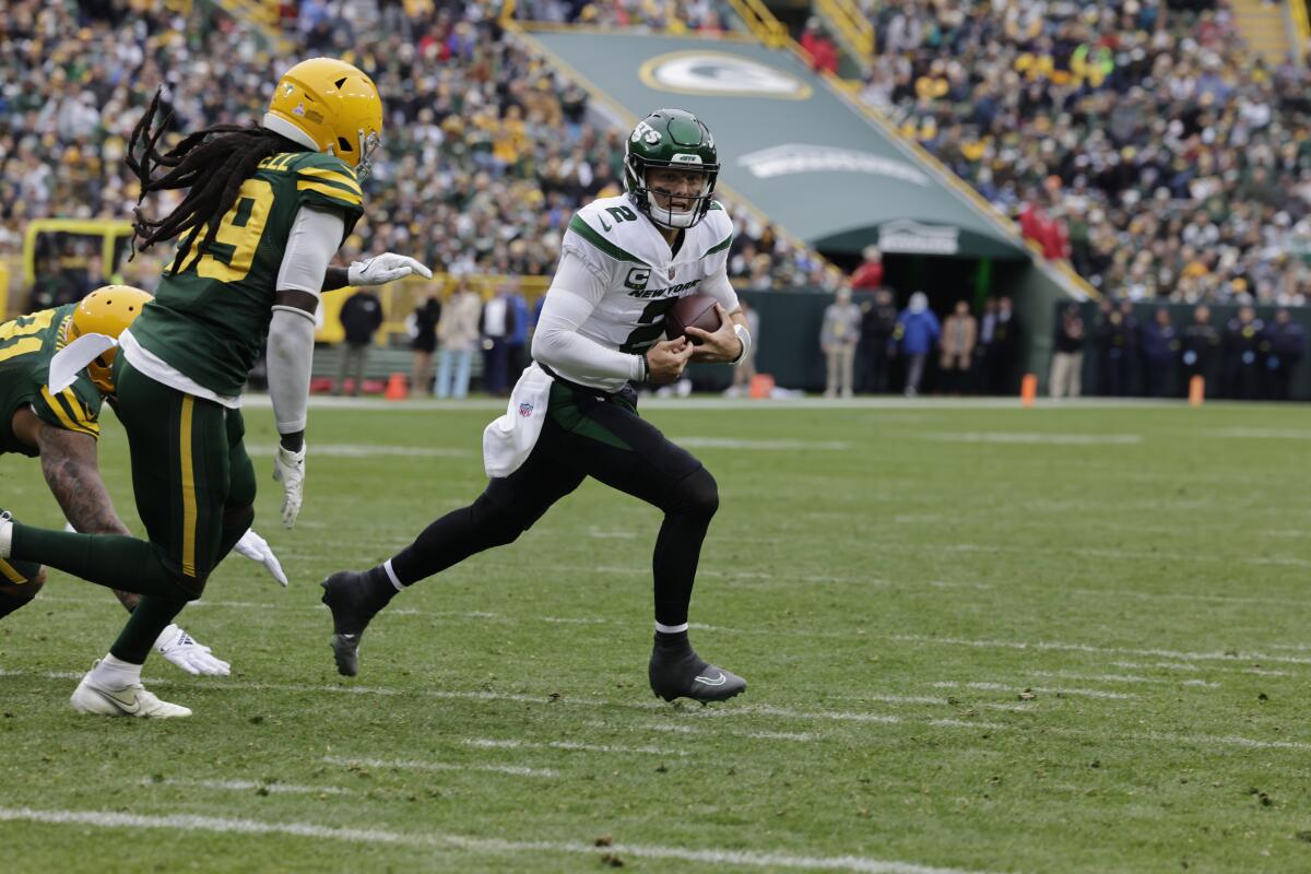 New York Jets quarterback Zach Wilson tries to elude Green Bay Packers linebacker De'Vondre Campbell.