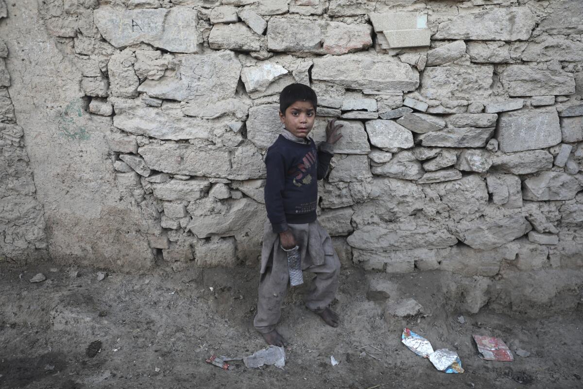 An internally displaced boy stands outside his temporary home in Kabul, Afghanistan, on Dec. 30. 