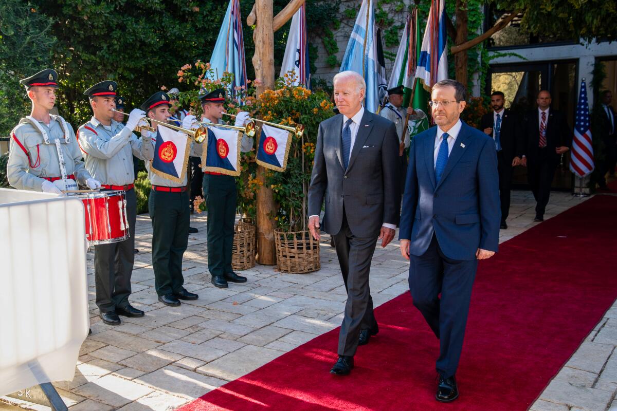 President Biden walks along a carpet with Israeli President Isaac Herzog