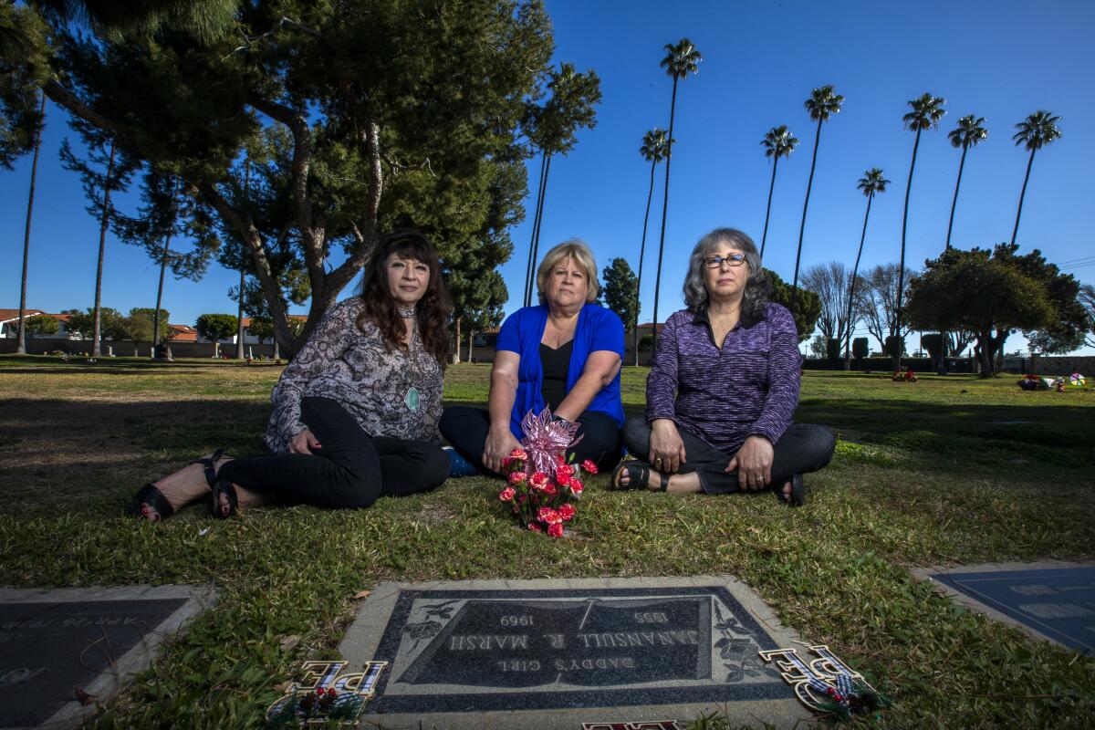 Three women seated before a grave 