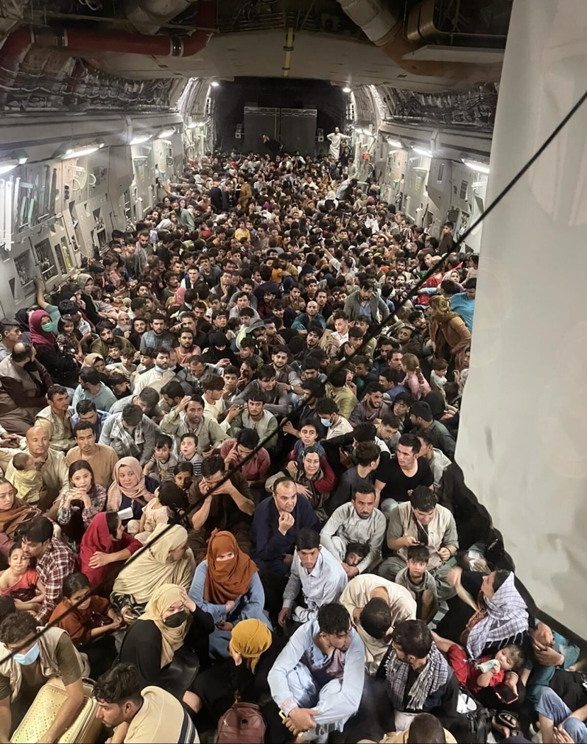 Afghan citizens pack a U.S. Air Force C-17 Globemaster III, as they are transported from Hamid Karzai International Airport.