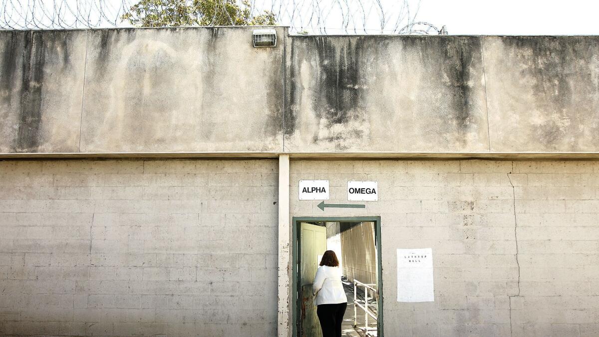 A Probation Department staff member passes through an old walkway at Central Juvenile Hall in Los Angeles on July 23, 2014.