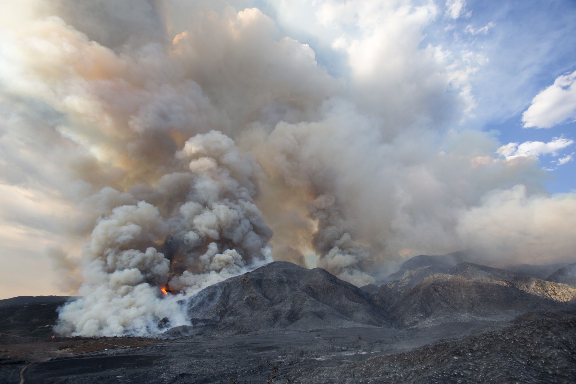 Smoke rises from a wildfire burning a hillside in Yucaipa, Calif.