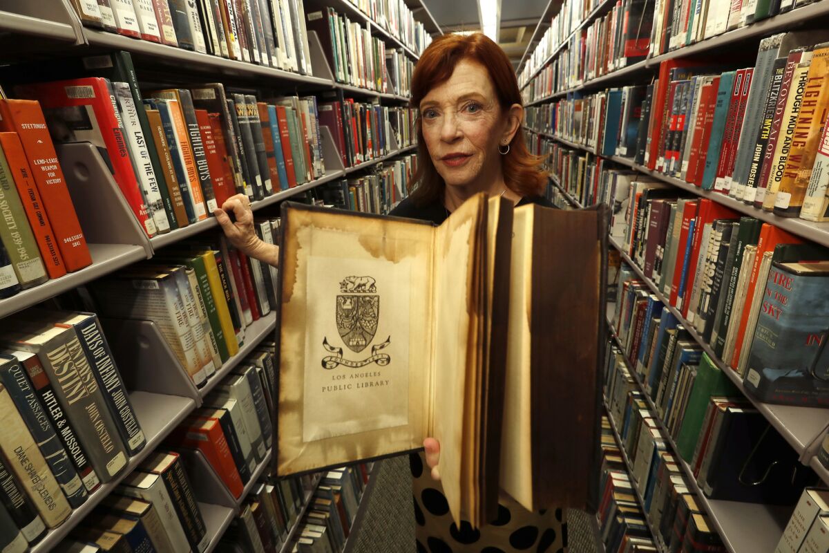 Susan Orlean displays a book that survived the devastating fire at the L.A. Central Library.