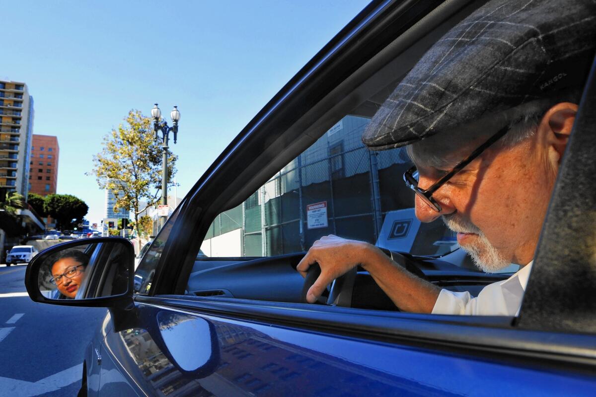 Los Angeles Times columnist Steve Lopez, moonlighting as an Uber driver, with his first customer, Eloisa Lopez, in downtown Los Angeles on Sept. 17.