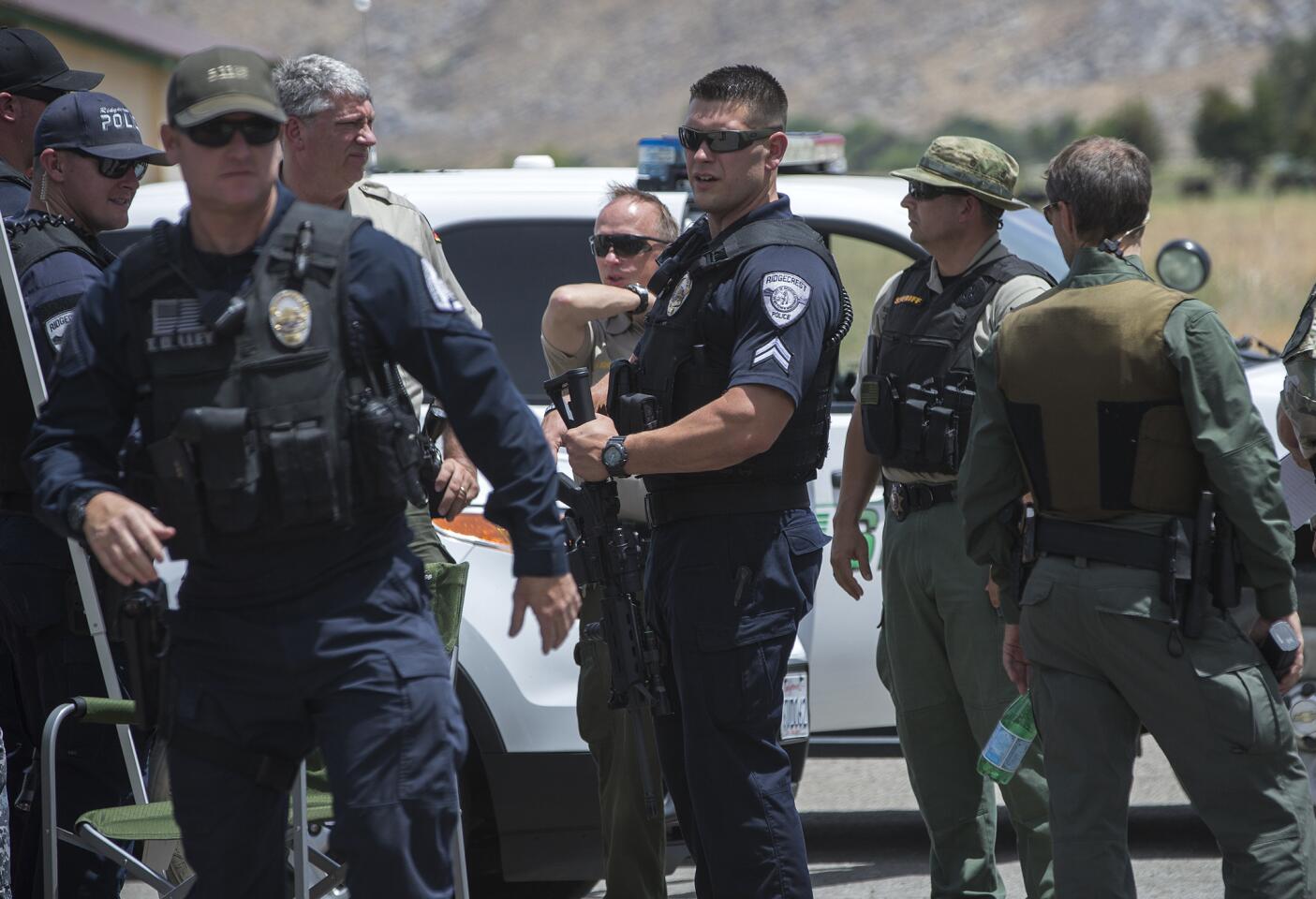 Ridgecrest Police officers join Los Angeles County and Kern County sheriff's deputies in the hunt for a slaying suspect who also shot and wounded two Kern County deputies near Jawbone Canyon and Kelso Valley roads in Weldon, Calif.