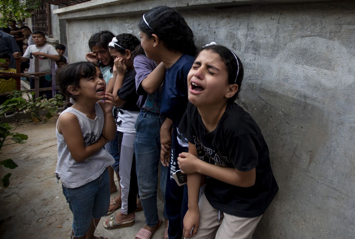 Children and others cry during the funeral of Tamim Hijazi, who was killed in an Israeli airstrike.