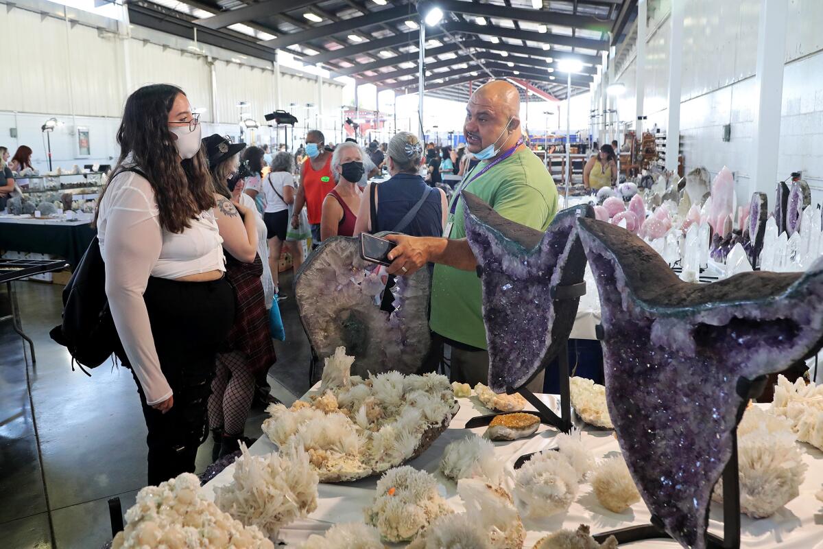 Aziz Ahmady, right, owner of Elegant Healing in Roseville, Calif., during Gem Faire at the OC Fair & Event Center, Aug. 27.
