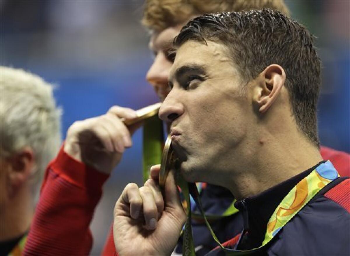 El nadador estadounidense Michael Phelps besa la medalla de oro del relevo 4x200 en los Juegos Olímpicos de Río de Janeiro el miércoles, 10 de agosto de 2016. (AP Photo/David J. Phillip )