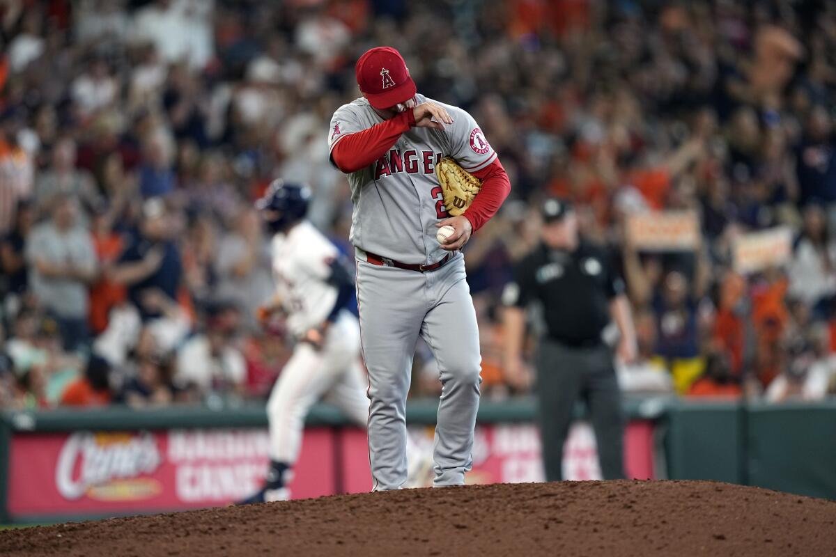 Angels reliever Aaron Loup wipes his face after giving up a home run to Houston's Chas McCormick.