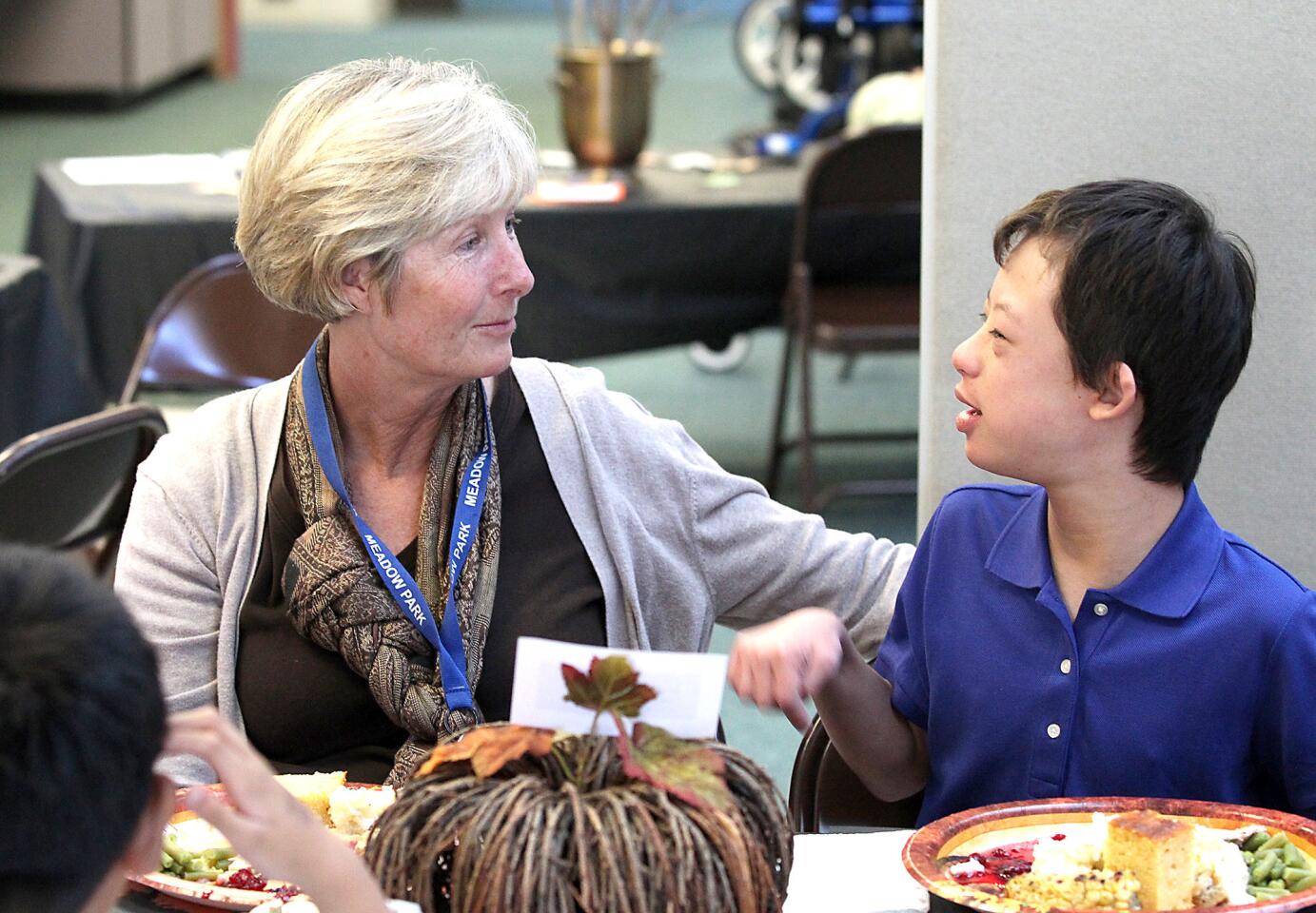 Speech therapist Julie Meves, left, chats with Danny Warschauer during the Meadow Park Elementary School's Thanksgiving meal event.