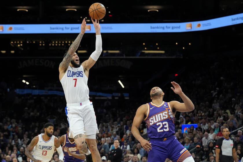 Los Angeles Clippers guard Amir Coffey (7) shoots over Phoenix Suns guard Eric Gordon (23) during the second half of an NBA basketball game Tuesday, April 9, 2024, in Phoenix. The Clippers won 105-92. (AP Photo/Ross D. Franklin)