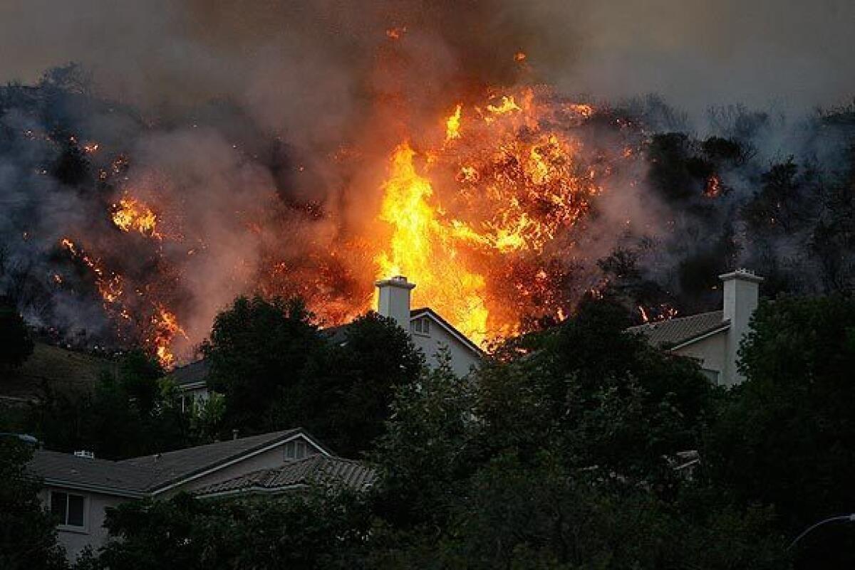 A back fire burns along a ridge above homes on Sky Ridge Drive in La Crescenta in 2009.