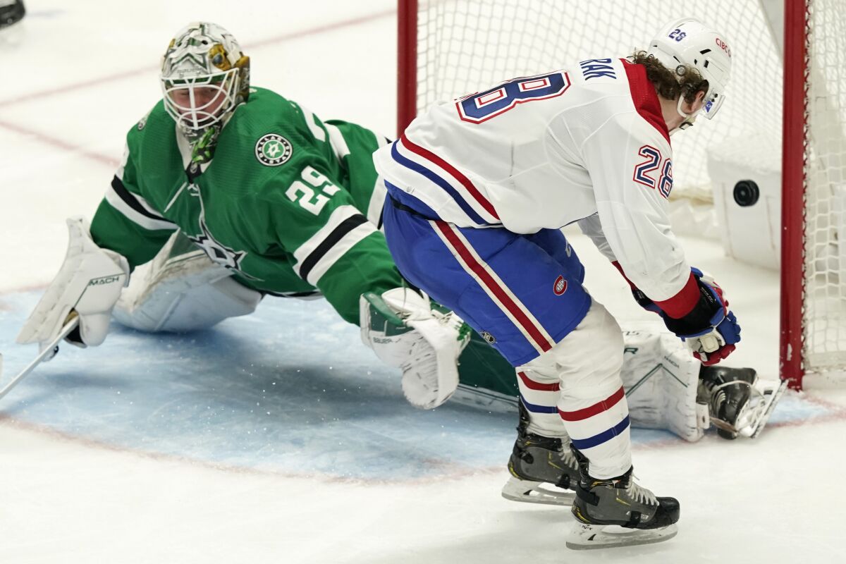 Montreal Canadiens left wing Christian Dvorak (28) scores a goal against Dallas Stars goaltender Jake Oettinger (29) during the third period of an NHL hockey game in Dallas, Tuesday, Jan. 18, 2022. The Canadiens won 5-3. (AP Photo/LM Otero)