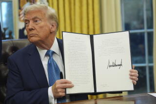 Donald Trump holding a signed executive order