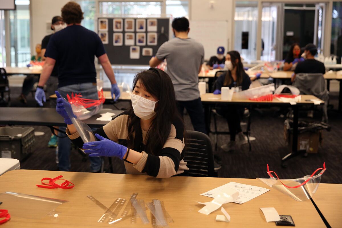 UCLA medical student Vivian Hu makes face shields with other volunteers.