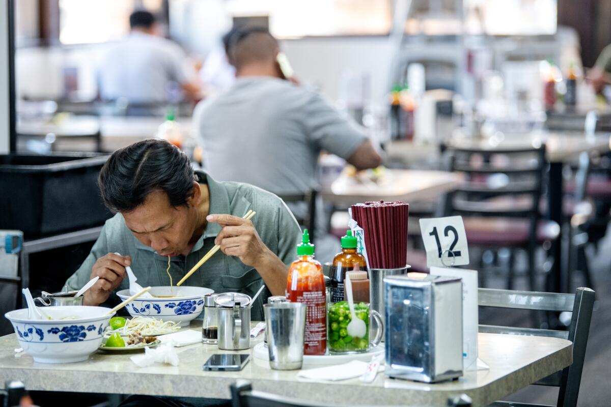 Customers dig into bowls of hu tieu at Trieu Chau Restaurant in Santa Ana.
