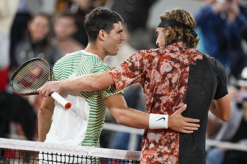 Spain's Carlos Alcaraz, left, is congratulated by Greece's Stefanos Tsitsipas after winning the quarterfinal match of the French Open tennis tournament in three sets, 6-2, 6-1, 7-6 (7-5), at the Roland Garros stadium in Paris, Tuesday, June 6, 2023. (AP Photo/Thibault Camus)
