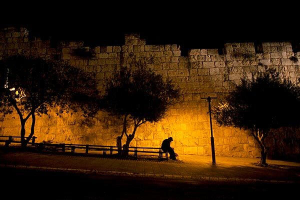 A man rests outside Jerusalem's Old City walls.