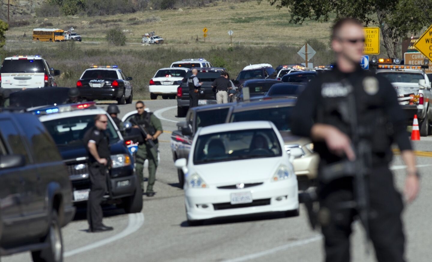 SWAT officers stand guard at a roadblock on Highway 38 north of Redlands as authorities search for former LAPD officer Christopher Dorner.