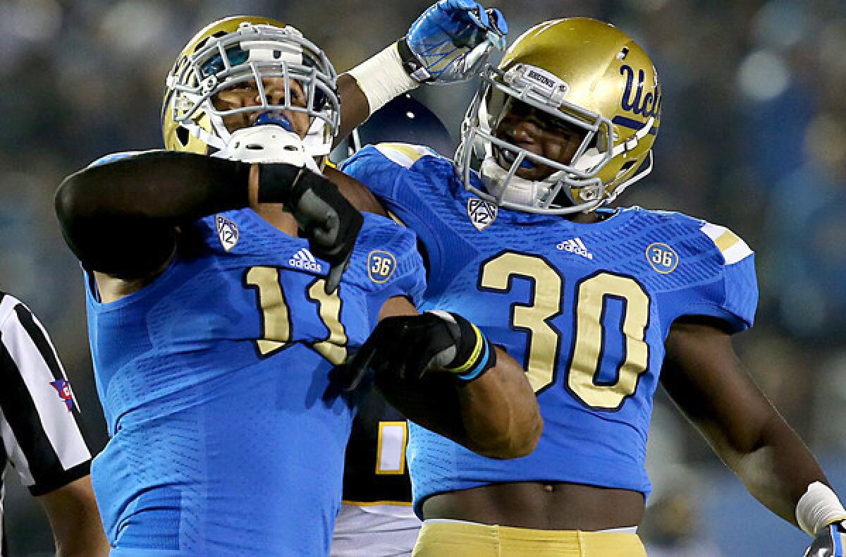 UCLA linebacker Anthony Barr, left, celebrates with teammate Myles Jack after recording a sack during the first quarter of Saturday's game.