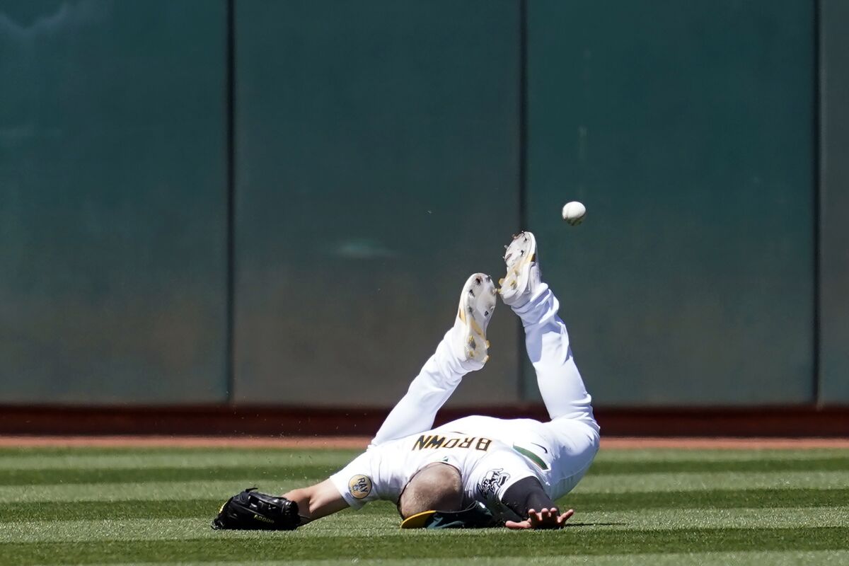 Oakland Athletics left fielder Seth Brown cannot catch a triple hit by Kansas City Royals' Michael A. Taylor during the seventh inning of a baseball game in Oakland, Calif., Saturday, June 18, 2022. (AP Photo/Jeff Chiu)