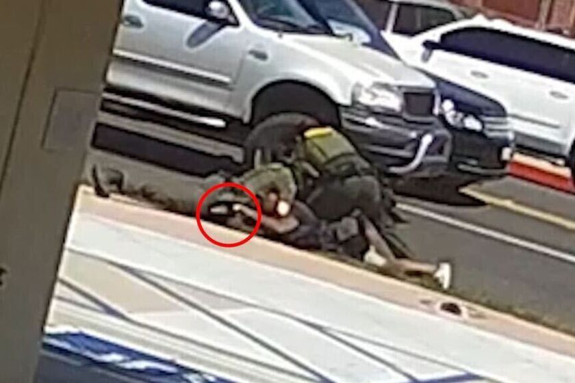 A still image from a security camera provided by the Orange County Sheriff's Department of the struggle between two deputies and a homeless Black man shot dead by one of the deputies. Sheriff Don Barnes said the red circle shows Kurt Reinhold hand on the deputy's gun.