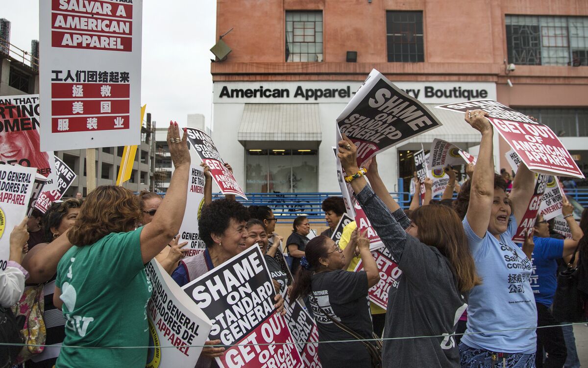 American Apparel workers protest the company's planned layoffs and store closures in front of the clothier's headquarters in downtown Los Angeles on Wednesday.