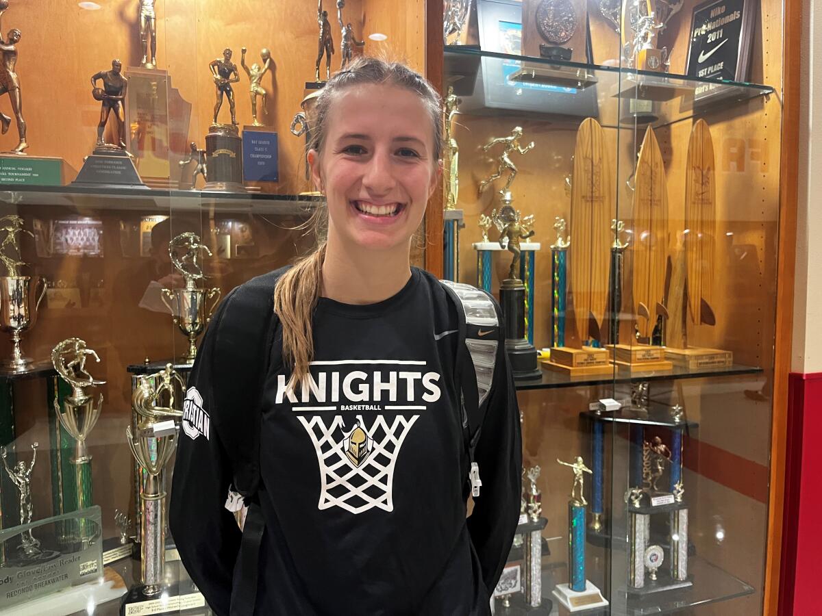 Ontario Christian High basketball star Chloe Briggs poses for a photo in front of a trophy case on campus.