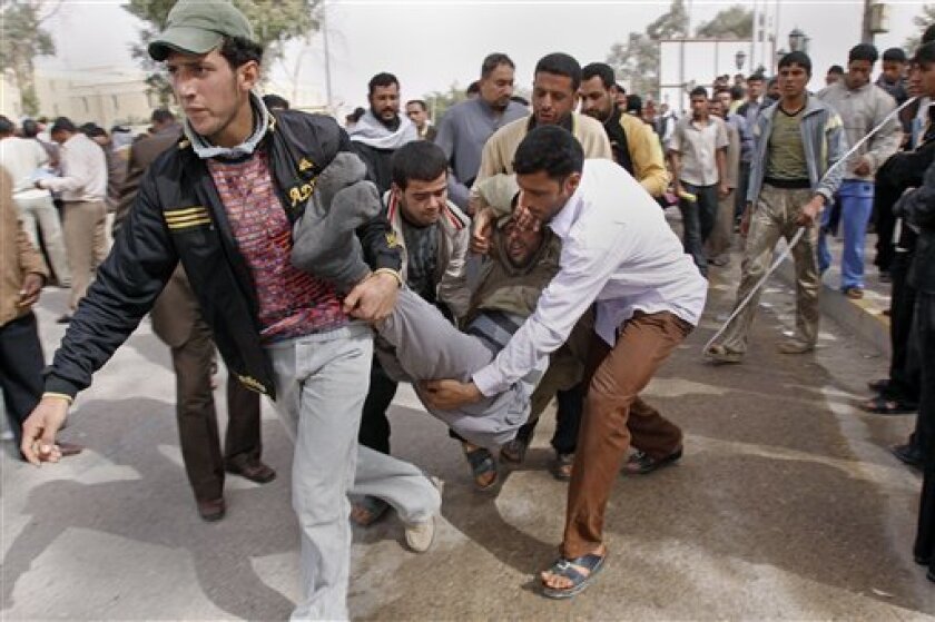 Iraqi anti-government protesters carry a man who collapsed during a demonstration in Basra, Iraq's second-largest city, 550 kilometers (340 miles) southeast of Baghdad, Iraq, Thursday, Feb. 17, 2011. Hundreds of Iraqi demonstrators massed Thursday in the southern city of Basra to demand the local governor's ouster while protesters elsewhere stormed a local government building, the latest examples of the anger sweeping the country over poor government services and high unemployment. (AP Photo/Nabil al-Jurani)