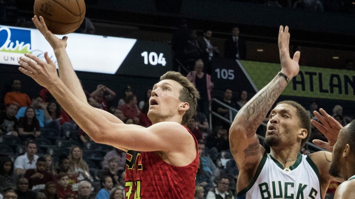 Hawks forward Mike Dunleavy gets past Bucks forward Michael Beasley for a layup during their game Sunday.