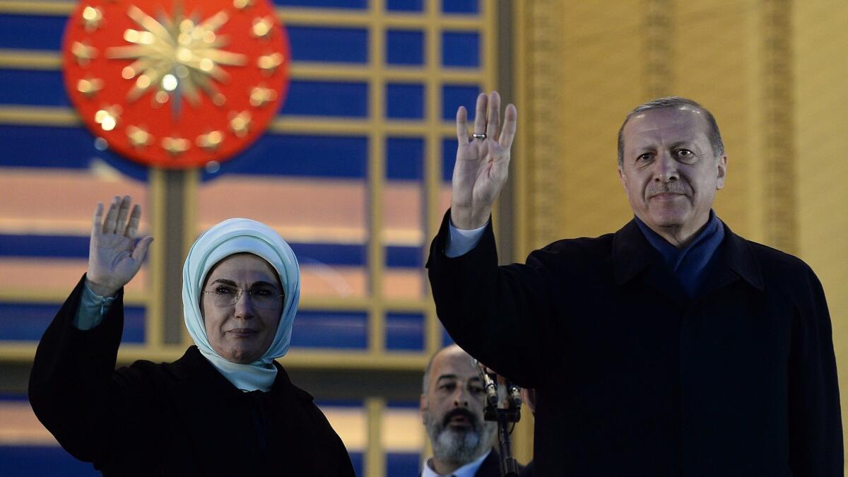 Turkish President Recep Tayyip Erdogan and his wife, Emine, greet supporters at the presidential palace in Ankara, Turkey, on Monday.